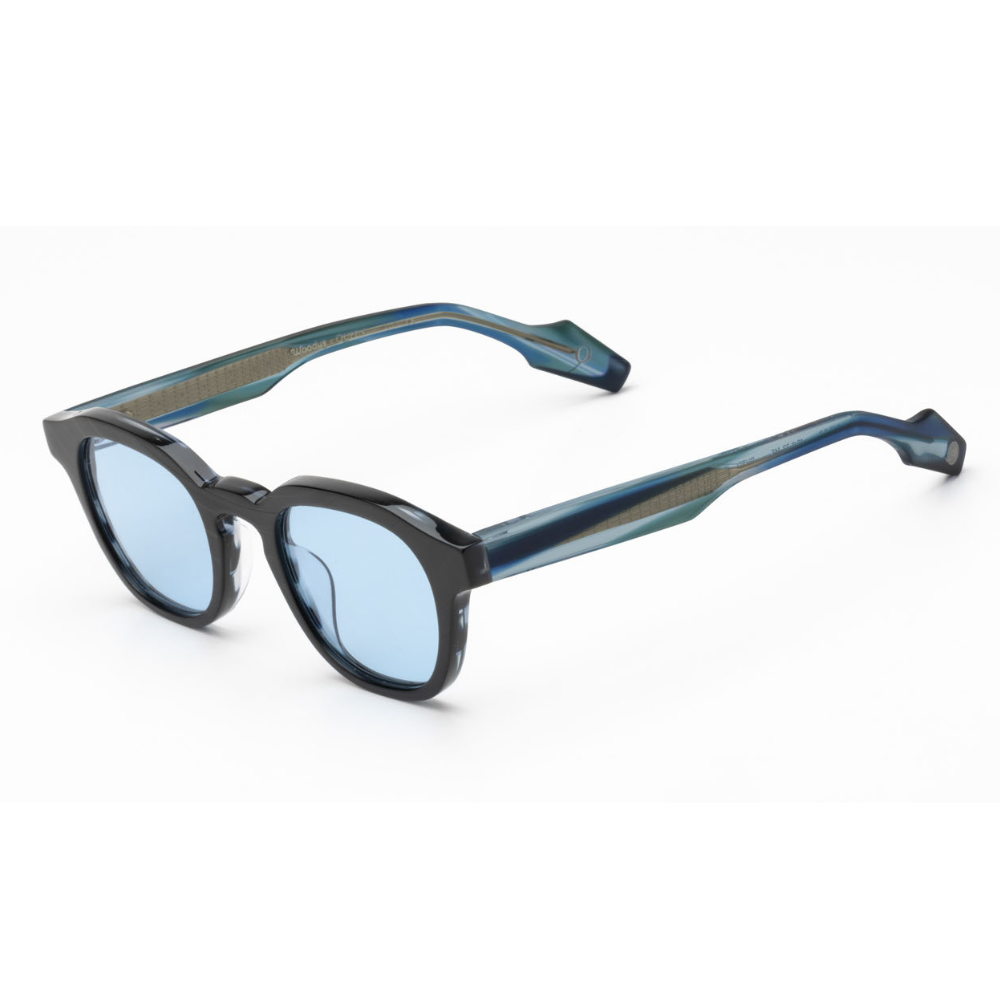 Woodys x Queen Dust C02 sunglasses – three-quarter view showing guitar-engraved metal core and laminated end-pieces
